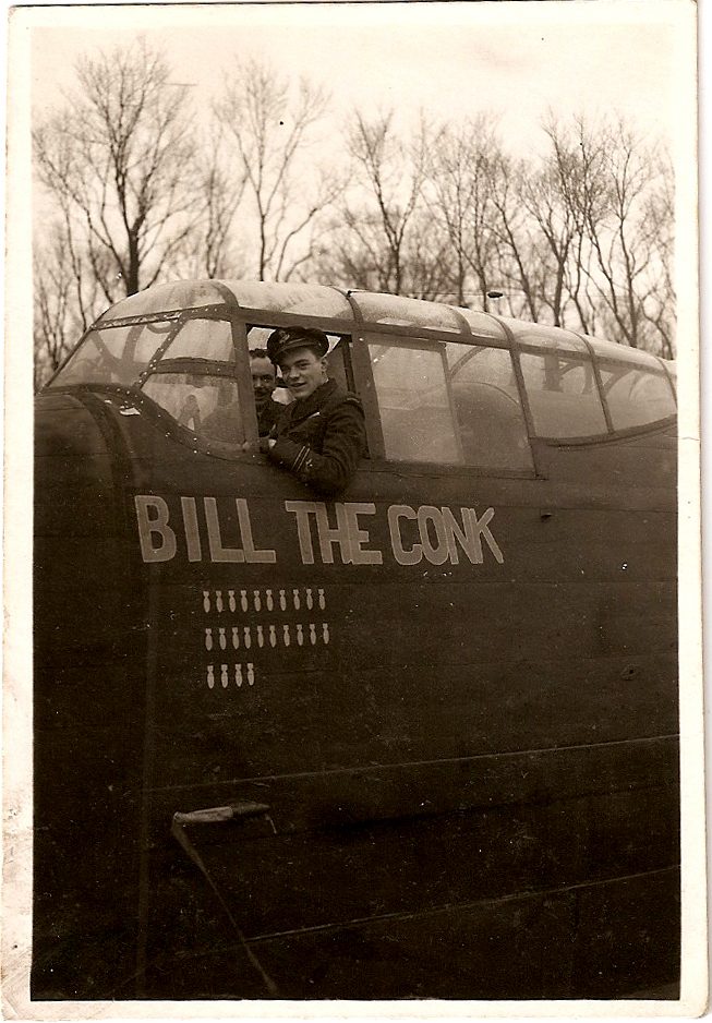 Flight Officer Bill Woods in the cockpit of his Lancaster bomber 'Bill the Conk', with 24 bomb mission tallies visible on the nose
